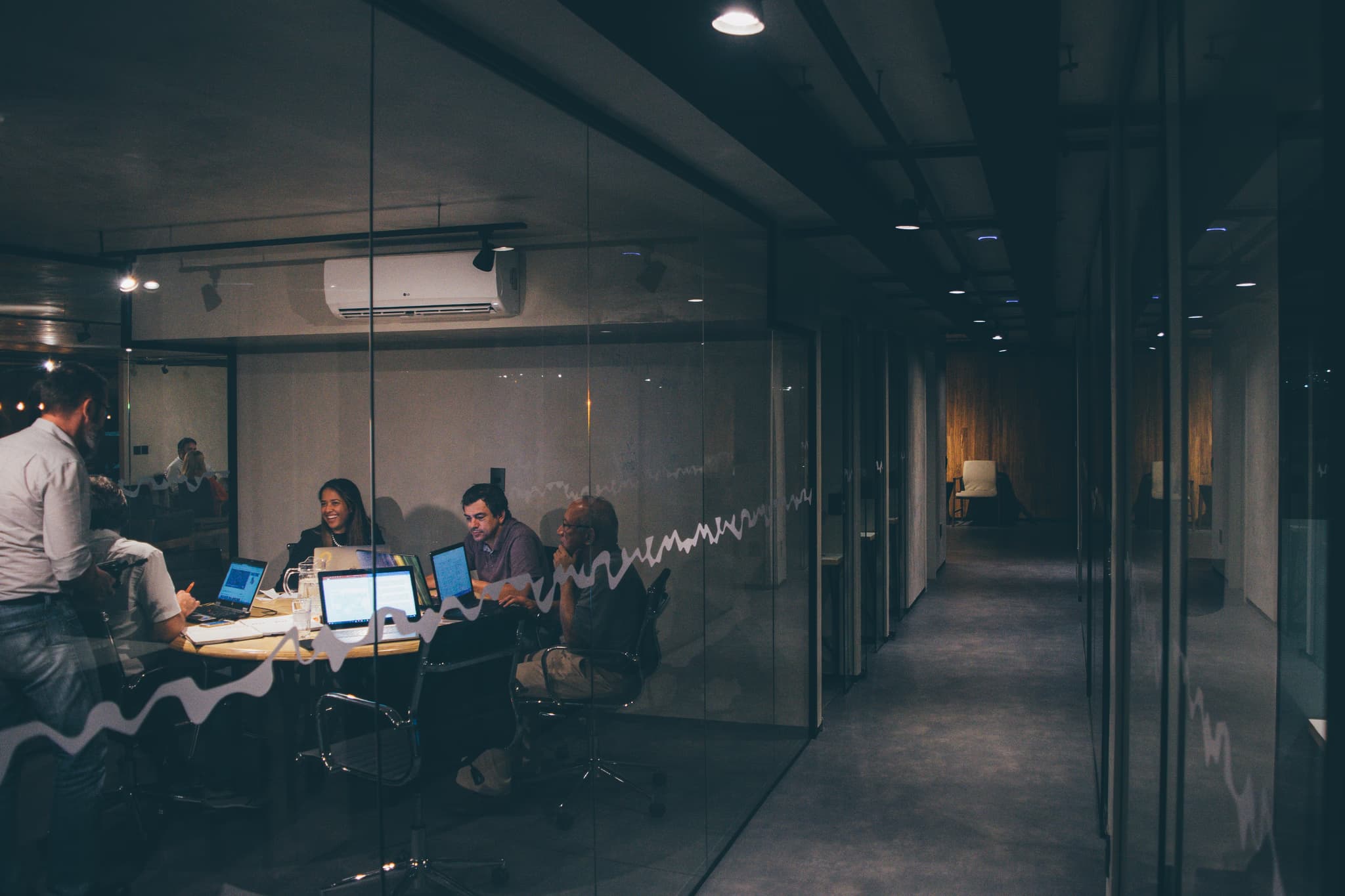 Dimly lit meeting room with team collaboration